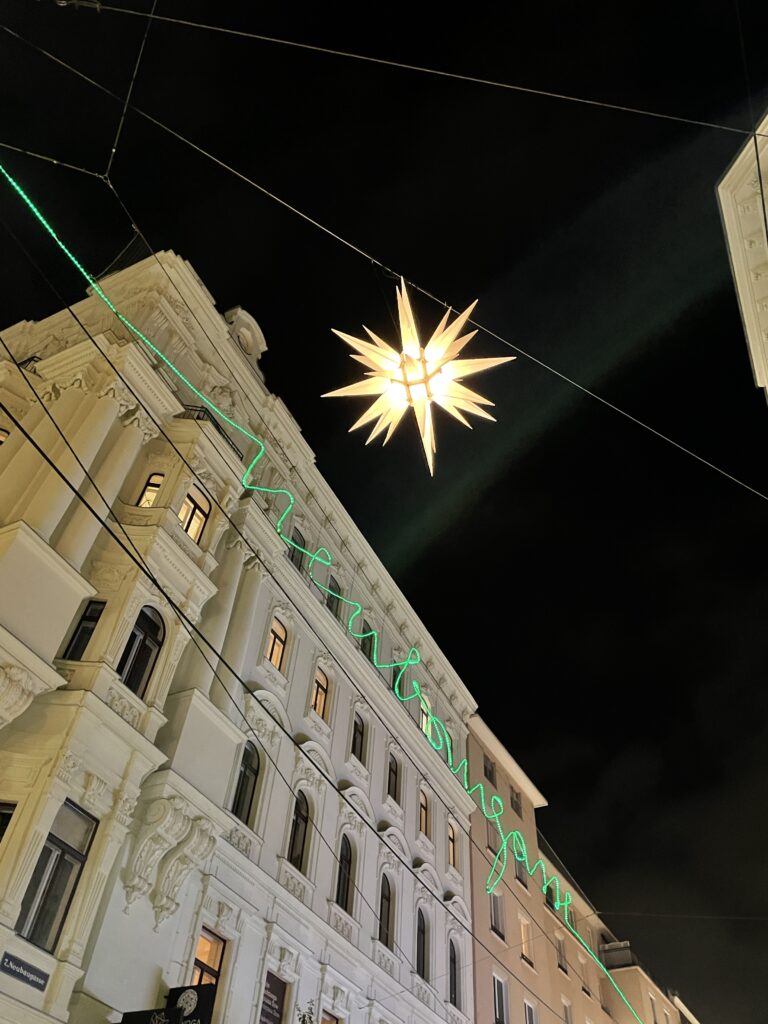 In der Neubaugasse beleuchten Herrenhutter Sterne im Advent den Abendhimmel. Die Weihnachtsbeleuchtung wurde in der Vergangenheit zur beliebtesten Wiens gewählt.